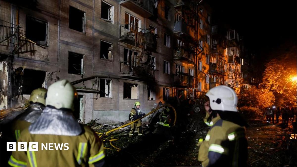 Firefighters work at the site of an apartment building hit by a Russian missile strike in Kyiv