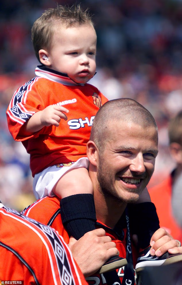 Brooklyn Beckham on dad David's shoulders following Manchester United's win against Tottenham Hotspur in May 2000