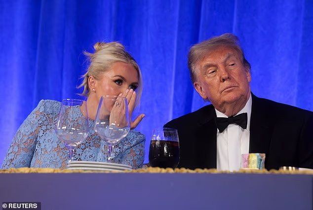 Karoline Leavitt speaks to President Trump at the White House Correspondents' Dinner in Washington last month