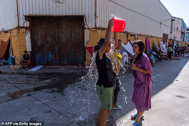 Migrants cool off with water in the Spanish North African enclave of Ceuta on August 7, 2026