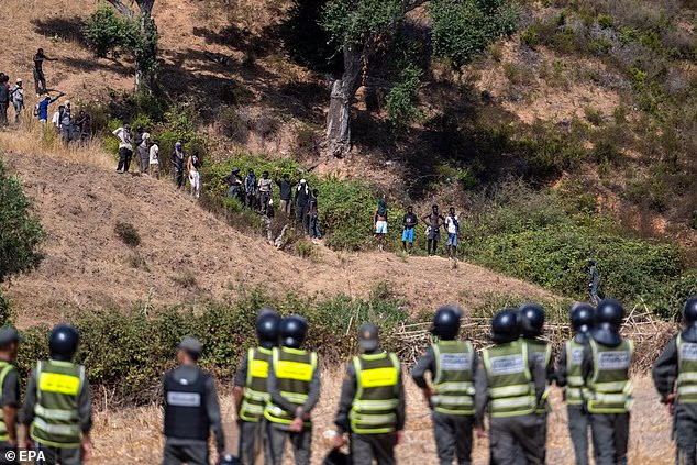 Moroccan security forces monitor as they thwart attempts by hundreds of sub-Saharan African and Sudanese migrants to enter Ceuta