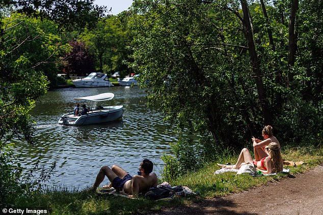 Pictured: People relax at The Ham and Kingston bathing site on June 23 before the Environment Agency warned people to stay away from blue-green algae