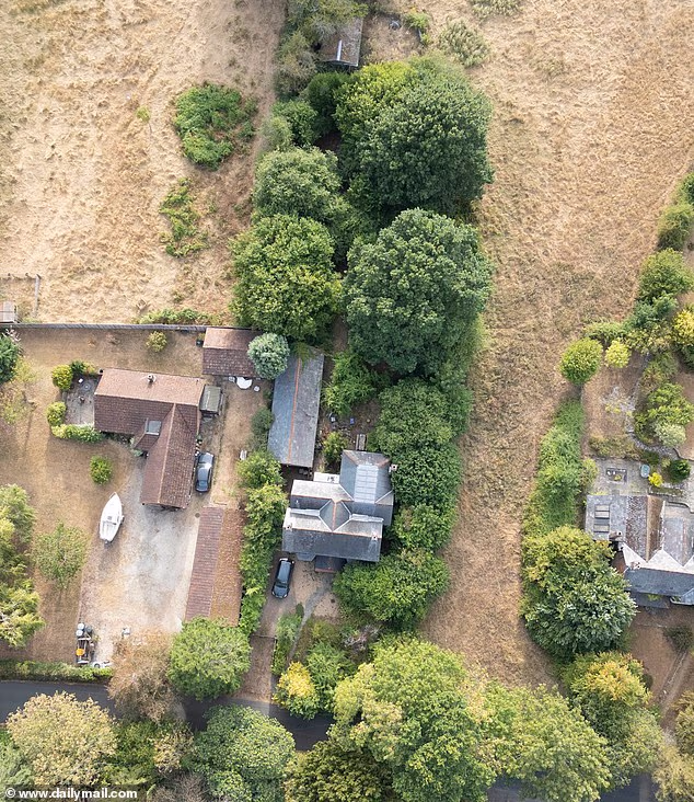 Charlie Dimmock's home in Romsey, Hampshire, has areas shrouded by lush green trees but grass beneath as well as surrounding fields have gone yellow and brown