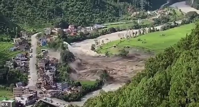 A wave erupts up across the bank of the Bhote Koshi River this morning in flash floods that have already claimed the lives of dozens