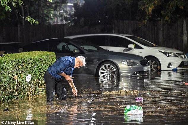 A man in Birmingham wades through the water after Britain's second city was hit with flooding