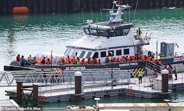 A migrant was found dead and three others were wounded on a small boat that was still allowed by authorities to continue on its voyage to the UK. Pictured: Migrants arriving at Dover on Thursday