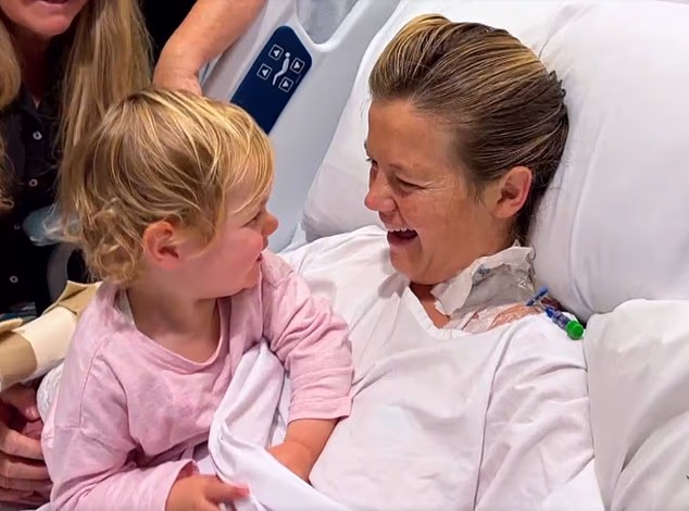 Leah Stewart (pictured in hospital with her daughter, August, shortly after waking from a coma) survived a horror shark attack at Coogee Beach on June 13