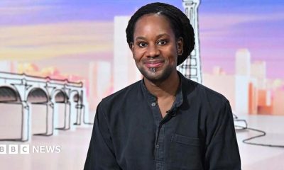 Jason Arday wears a black shirt and smiles at the camera as he appears as a guest on the panel of BBC show Sunday with Laura Kuenssberg
