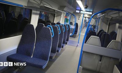 A row of dark blue seats on a train.