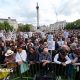A crowd of people gather in Trafalgar Square as part of a vigil for Jason Arday. Some of them are holding placards.