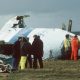 Emergency service workers stand next to the wreckage of Pan Am flight 103 in a field east of Lockerbie.
