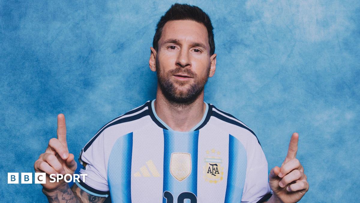 Lionel Messi poses in a photoshoot, with the index fingers of both hands pointing upwards