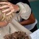 A student with blonde hair holds their hand to their head as they look at their GCSE results at the City of London Freemen's School