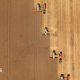 An aerial image of a brown field of crops being harvested by four combine harvesters