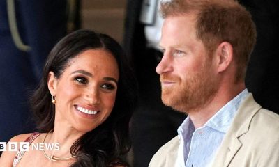 Prince Harry and Meghan sat next to each other and smiling in Colombia in 2024