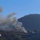 A few people are seen working at a blackened site on a mountain
