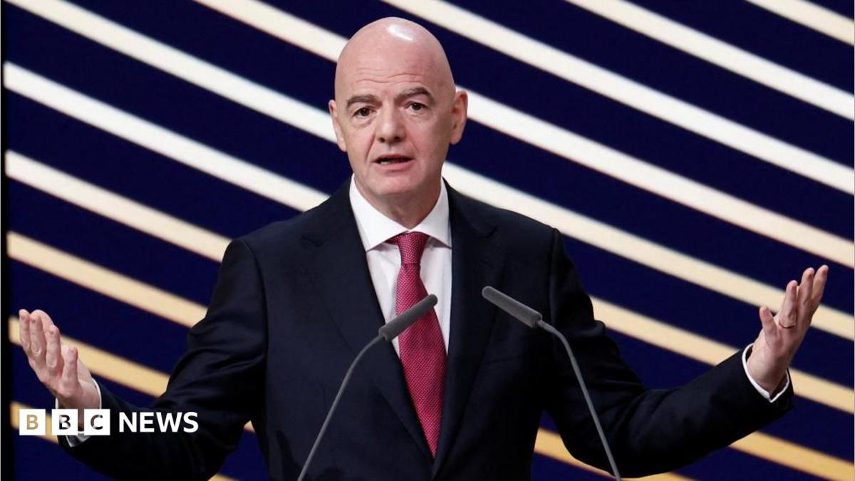 FIFA president Gianni Infantino speaks during an event, standing in front of a purple and yellow striped background.