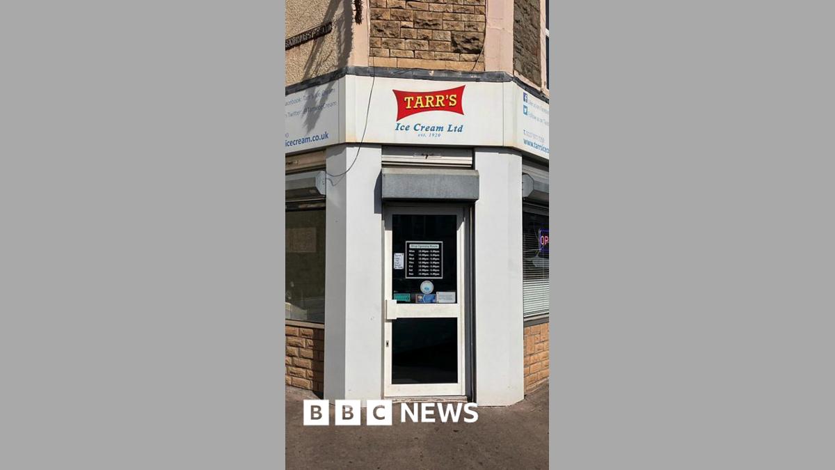 The front of an ice cream shop, painted white with a red and yellow logo reading Tarr's