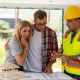 A couple looks at plans with a builder in their home, which is under renovation