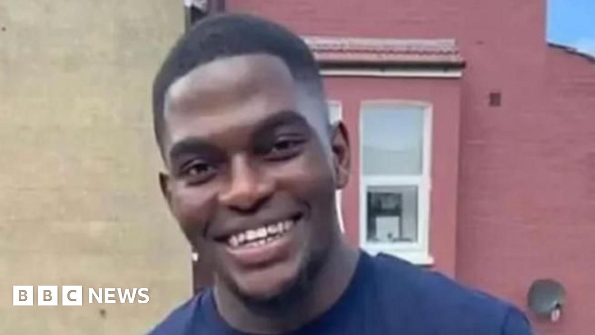 File image of Chris Kaba, a young man with short hair wearing a blue T-shirt and smiling at the camera.