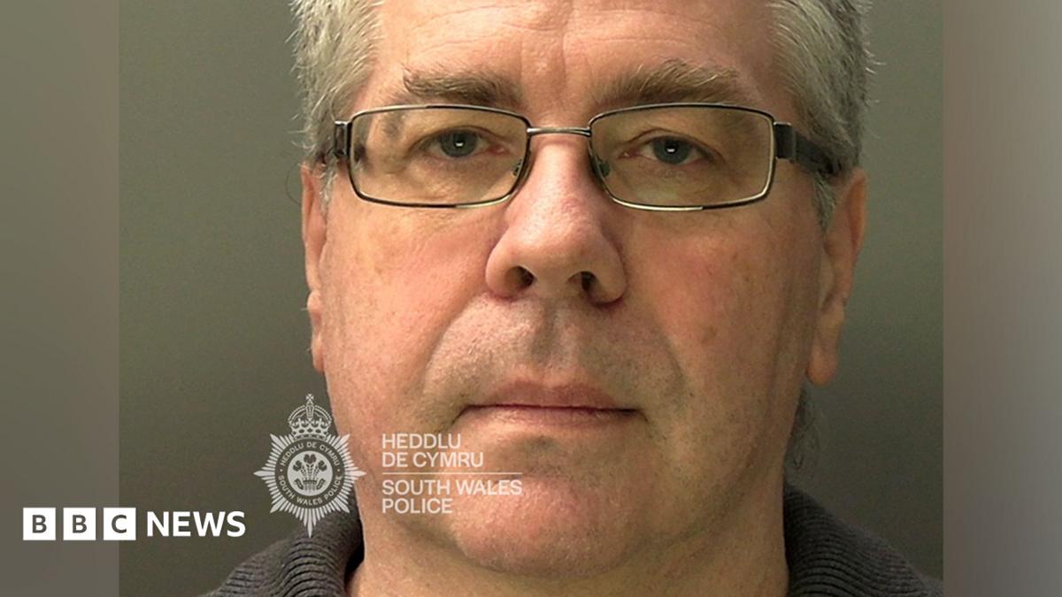 A mugshot of Christopher Phillips, who has grey hair and glasses