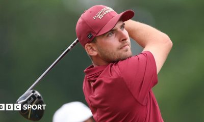 Jack Whaley, in red golf shirt and cap, tees off and watches his shot