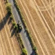 This aerial view shows a vehicle driving down a road with dried out farm fields on either side following months of little or no rain, in the village of Lullingstone, Eynsford, south-east of London on August 6, 2026.
