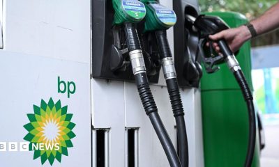 Close up of petrol and diesel pumps and hand on one of the pumps with the BP logo to the side