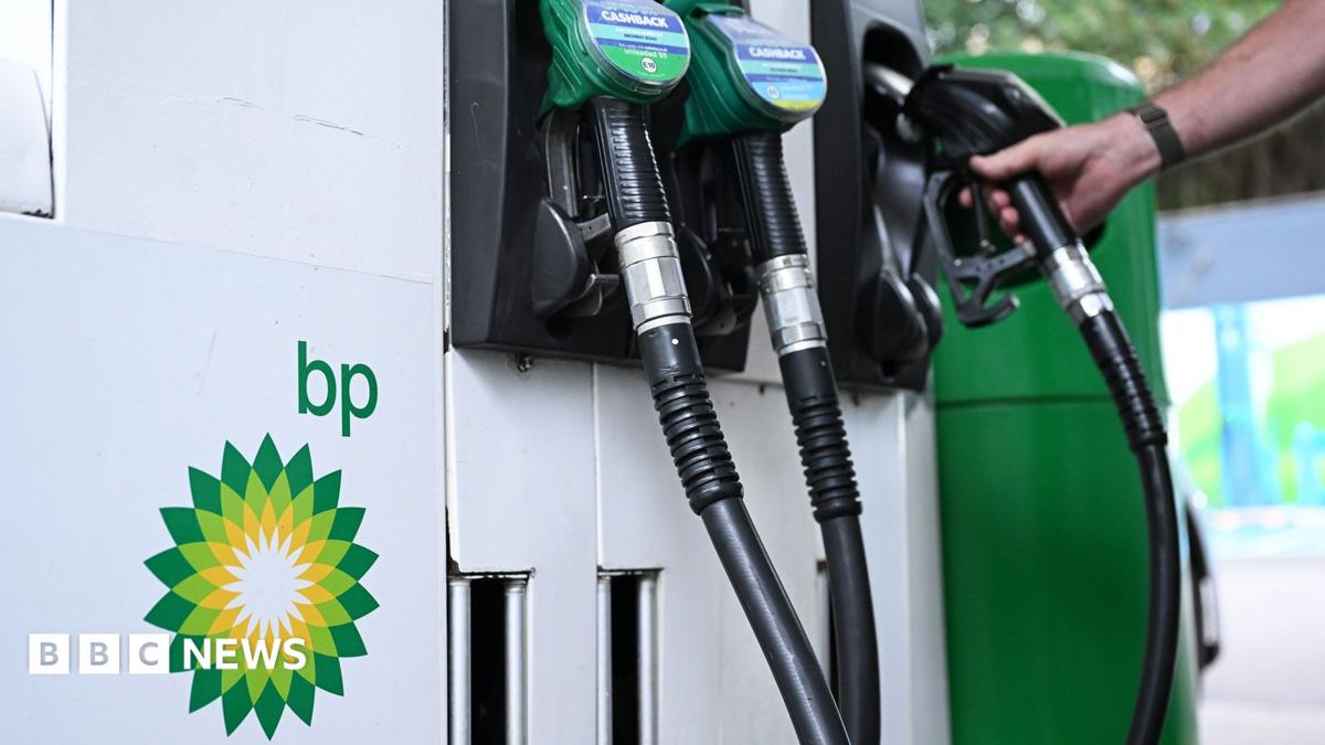 Close up of petrol and diesel pumps and hand on one of the pumps with the BP logo to the side
