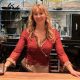 Caroline Kraetzer stands behind a bar, with her hands on the counter.