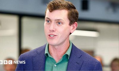 Flock founder and chief executive Garrett Langley wearing a blue suit jacket and green shirt