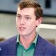 Flock founder and chief executive Garrett Langley wearing a blue suit jacket and green shirt