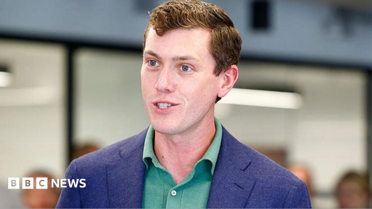 Flock founder and chief executive Garrett Langley wearing a blue suit jacket and green shirt