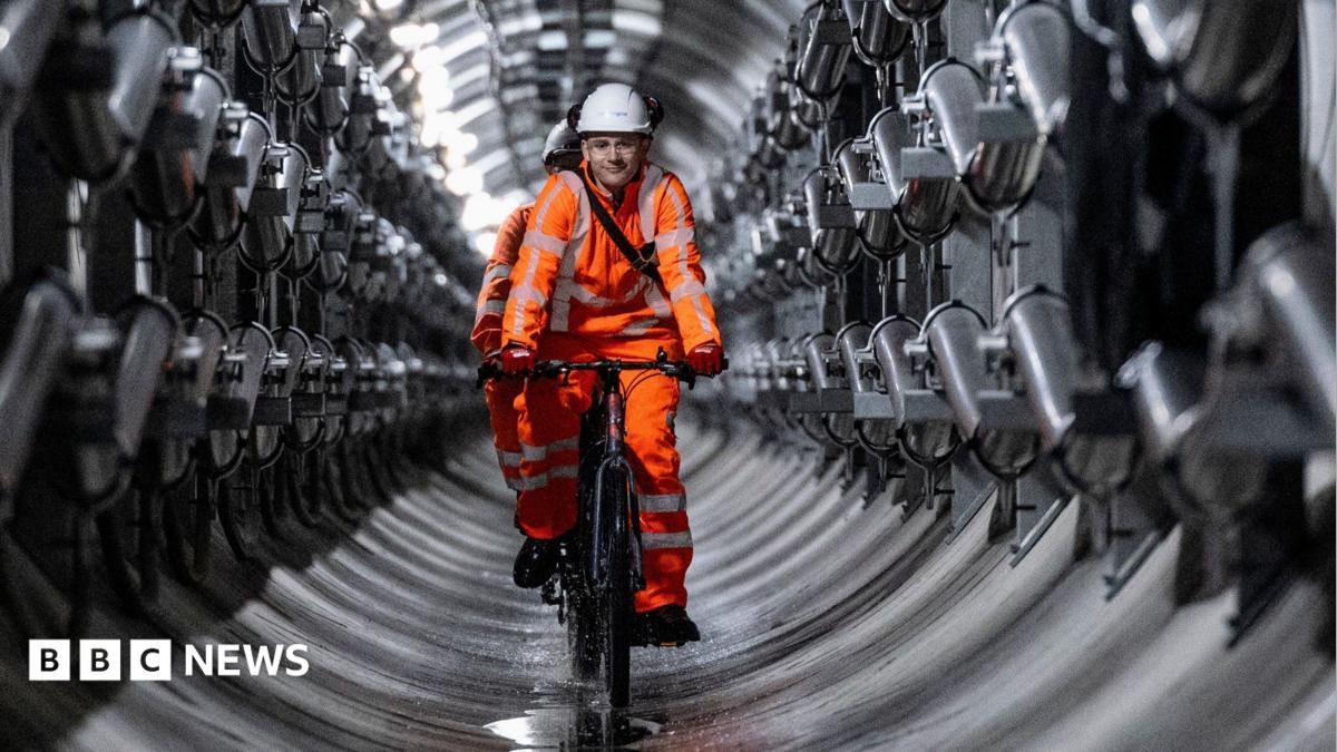 Four engineers stand close to a large metal cylinder which containers the Earthgrid boring machine.