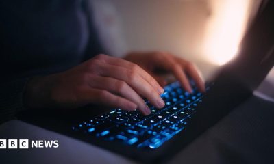 Close-up hands of female using laptop in bed at night