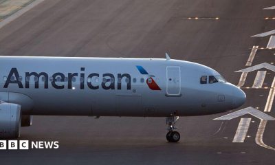 The front of an air plane with the American logo on a runway.