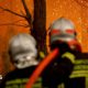 Two firefighters direct a hose at a burning forest around 30km from Bordeaux, on July 26, 2026.