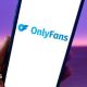 A phone with the OnlyFans logo on the screen