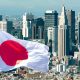 A Japanese flag flies in front of the Tokyo skyline