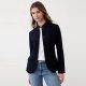 A woman wearing blue jeans, a white top, and navy blazer
