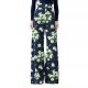 A woman wearing a navy, green, and white floral pant and gold shoes, plus a navy top with a couple of white flowers