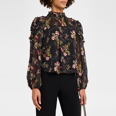 A woman wearing black pants and a black floral blouse