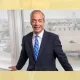 Nigel Farage of Reform UK posing against an internal window frame, smiling