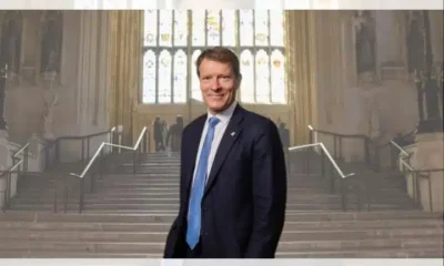 Richard Tice of Reform UK photographed on the Parliament estate in a large open room with steps and a large window behind him