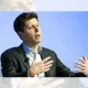 Sam Altman, CEO of OpenAI, mid-speech sat down with his hands gesturing