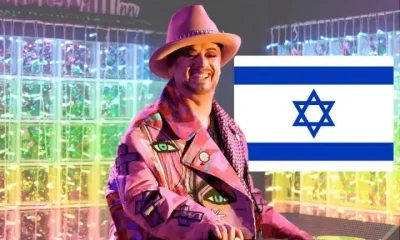 Boy George and the flag of Israel on one side with rainbow-coloured lights in the background of the image