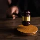 A hand holds the end of a court gavel to visualise the German court story