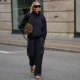 Mirja Klein is seen wearing a navy zip front jacket with a high collar from The Frankie Shop; matching navy cargo trousers with a self tie belt from The Frankie Shop; brown leather flip flops from A.Emery; a medium sized olive suede top handle bag from DeMellier; oversized rectangular acetate sunglasses with dark tinted lenses from Phoebe Philo; blonde hair worn long with a center part during the Copenhagen Fashion Week Spring/Summer 2027 on August 6, 2026 in Copenhagen, Denmark.