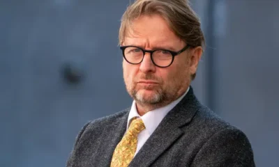 Professor David Miller in a smart suit and bright tie looking stern in 2023 outside the centre where his tribunal hearing was taking place
