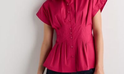 A woman wearing black pants and a dark pink pleated top